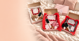 Collection des coffrets HerBeauty présentée sur un lit