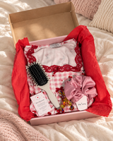 Coffret HerBeauty Rose ouvert sur un lit